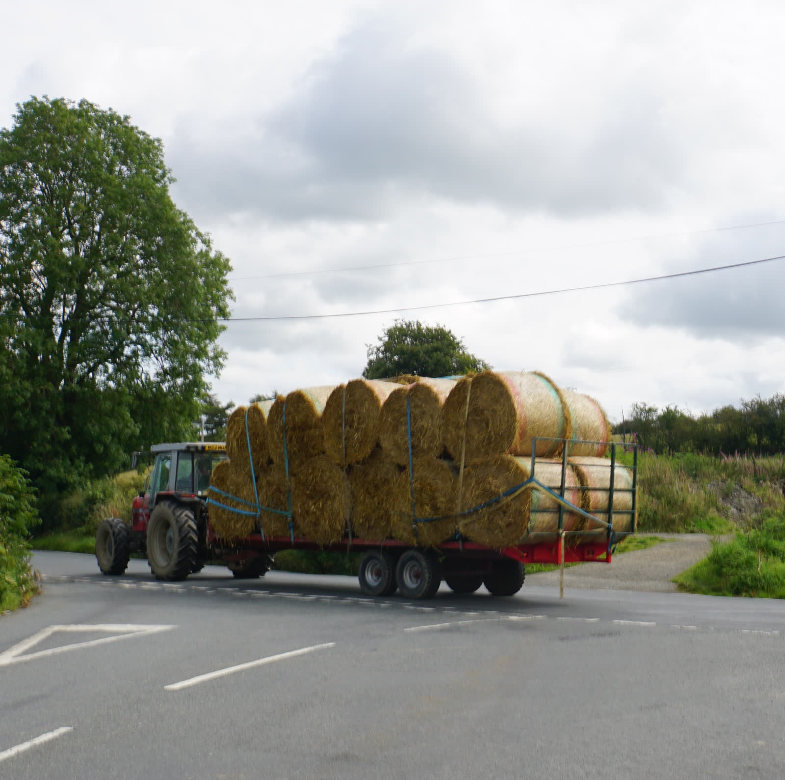 Hay trailer stacked with large round bales, the kind of load we run on a 30–36 foot gooseneck